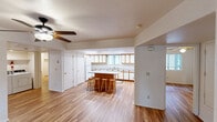 Located at 25 South Maricopa Street in Flagstaff, Arizona, this single-floor residence offers four bedrooms, five bathrooms, and generous overall living space. Warm hardwood-style flooring runs throughout, lending a cohesive and inviting feel to every room.

Each of the four bedrooms is bright and airy, featuring ceiling fans with light fixtures and windows that bring in natural light. Several bedrooms include dedicated vanity areas with built-in countertops and mirrors, as well as adjacent closets, providing convenient, private storage for each occupant. The primary bedroom offers a comfortable footprint with its own closet and vanity space.

The bathrooms are clean and functional, each equipped with a full tub-shower combination and high-set windows that allow natural light while maintaining privacy. The five bathrooms ensure ample accommodation for all residents.

The kitchen is well-appointed with white cabinetry featuring warm wood trim accents, a central island with a white countertop, a gas range, built-in microwave, dishwasher, and a double-basin sink. Recessed lighting illuminates the space efficiently, and a window provides additional brightness.

A hallway connects the rooms cohesively across the single floor. The overall layout is practical and well-organized, making this Flagstaff home well-suited for shared or family living.