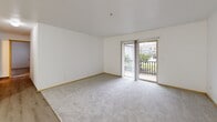 Located at 4317 NE 66th Ave in Vancouver, Washington, this two-bedroom, one-bathroom unit offers a practical and well-organized single-floor layout. The living room serves as the central gathering space, featuring a mix of hardwood-style and plush carpeted flooring, clean white walls, and a sliding glass door that opens directly onto a private balcony — allowing natural light to fill the room and providing outdoor views of the surrounding neighborhood. An adjacent dining area connects seamlessly to the living space, enhancing the open feel of the common areas. The kitchen is equipped with dark wood cabinetry, a speckled gray countertop, a white electric range, and light wood-style flooring, offering a functional cooking environment. Both bedrooms are carpeted and feature natural light through blinded windows, baseboard heating, and sliding or hinged closet doors for storage. Three closets throughout the unit provide ample additional storage. The bathroom includes wood-style tile flooring, a light wood vanity with a gray countertop, a wall-mounted mirror, and a full tub-shower combination with grab bars. A dedicated laundry area adds everyday convenience. Warm wood trim throughout ties the interiors together with a cohesive, understated aesthetic.