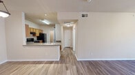 Located at 5400 Sycamore School Road in Fort Worth, Texas, this one-bedroom, one-bathroom unit offers a well-organized single-floor layout designed for comfortable everyday living. The combined kitchen and living area forms the heart of the home, with the kitchen showcasing warm honey-toned wood cabinetry, granite-style countertops, a peninsula with a double stainless steel sink, and a full suite of black appliances including a range, over-the-range microwave, and refrigerator. The peninsula opens directly to the living area, promoting an open, connected feel throughout. Wood-style flooring runs consistently through the main living spaces, adding warmth and visual continuity. The spacious bedroom features a ceiling fan, a closet, and a large window that allows natural light to brighten the room with exterior views of the surrounding community. The bathroom includes a soaking tub with white tile surround, providing a relaxing retreat. A dedicated laundry room with washer and dryer connections and overhead wire shelving adds practical convenience. Throughout the unit, neutral warm-beige walls, clean white trim, and ceiling fans in key rooms contribute to a bright, cohesive, and functional living environment.