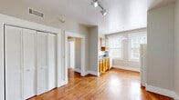 Located at 855 Mulberry St in historic Macon, Georgia, this well-appointed one-bedroom, one-bathroom unit offers an efficient and comfortable single-floor layout. Rich hardwood flooring flows throughout the space, lending warmth and cohesion to every room.

The open living area is bright and welcoming, benefiting from natural light streaming through large double-hung windows framed by clean white trim. Track lighting overhead provides additional illumination. A louvered bi-fold closet door adds a classic touch and practical storage to the living space.

The kitchen is thoughtfully designed, featuring warm honey-toned wood cabinetry, dark speckled countertops, a stainless steel sink, and a gas range. Dual windows in the kitchen allow abundant natural light, creating an airy cooking environment. A dishwasher and ample upper and lower cabinet storage complete the space.

The bedroom is a comfortable retreat, finished with the same gleaming hardwood floors, a ceiling fan with light fixture, and a bright window. Generous closet space is provided, with a total of three closets throughout the unit, along with dedicated laundry and hallway areas for added convenience.

The bathroom showcases classic white subway tile surrounding a full bathtub, accented by a bold dark tile border, black floor tile, and a window for natural ventilation. The overall aesthetic is clean, timeless, and move-in ready.