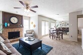 Located at 4415 Northcrest Dr in Midland, Texas, this single-story home offers a well-organized layout with inviting living spaces throughout. The living room serves as the heart of the home, centered around a classic brick fireplace with a striking wood-panel surround that extends to the ceiling. Ceiling fans in each room provide comfort, while natural light streams through multiple windows fitted with blinds. Soft carpeting runs throughout the main living areas, adding warmth underfoot.

The living and dining areas flow seamlessly together, with the dining space accommodating a full dining set and benefiting from a set of glass doors that invite natural light. A mirrored wall in the dining area enhances the sense of openness. The kitchen features warm wood cabinetry, stone-toned countertops, hardwood-style flooring, and full appliances including a range, microwave, and ample storage behind louvered pantry doors.

The bedroom is a calm retreat, finished with plush carpeting, a ceiling fan, and generous wall space. The bathroom is well-appointed with a wood-trimmed vanity, stone-look countertop, wood-framed medicine cabinet mirrors, and a full tub-shower combination with tiled surround. Throughout the home, a textured ceiling treatment adds a consistent architectural detail, tying the spaces together cohesively.