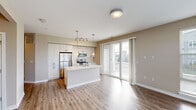 Located at 2100 Haddonfield Rd in Pennsauken, NJ, this well-appointed 2-bedroom, 2-bathroom residence offers a thoughtfully designed single-floor layout with a clean, contemporary aesthetic throughout. The open-concept living and kitchen area serves as the heart of the home, showcasing light wood-tone cabinetry extending to the ceiling, stainless steel appliances, and a central island with a white countertop and pendant lighting above. Hardwood-style flooring runs throughout the main living areas, while sliding glass doors lead to a private balcony, filling the space with natural light and offering outdoor views. A large bank of windows in the living room further enhances the bright, airy ambiance. Both bedrooms are generously proportioned, featuring neutral carpet, warm beige walls, and ample natural light. The primary bedroom includes a dedicated bathroom with a glass-enclosed walk-in shower, light wood vanity cabinetry, and hardwood-style flooring. The second bathroom mirrors the modern finishes, offering a full tub-shower combination with subway tile surround and a wide vanity with a mirrored medicine cabinet. Two hallways connect the rooms efficiently, and a dedicated closet provides additional storage. The overall design palette of warm neutrals and contemporary fixtures creates a cohesive, move-in-ready environment.