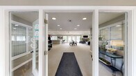 Located in South Rockwood, Michigan, this single-floor community space offers a thoughtfully designed layout that balances functionality with comfort. The entrance welcomes visitors with clean lines and neutral tones, setting the tone for the rest of the space.

The expansive kitchen and living room serves as the heart of the facility. The kitchen features warm-toned cabinetry, black appliances including a gas range, microwave, and refrigerator, set against a vaulted ceiling with recessed lighting. A curved, extended breakfast bar with modern bar seating provides an inviting area for casual gatherings. The adjoining living area is generously sized, featuring a ceiling fan, a fireplace framed by a classic surround, a wall-mounted television, and plush carpeting throughout. Large windows with vertical blinds flood the space with natural light and offer outdoor views, while a billiards table adds a recreational touch.

The dedicated exercise room is well-equipped with a variety of cardio and strength-training machines, including ellipticals, cable systems, and treadmills. Natural light enters through large windows, creating an energizing workout environment.

Throughout the space, a cohesive neutral color palette, recessed lighting, and carpeted flooring create a clean, welcoming ambiance suited for community use.