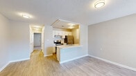 Located at 1004 Appamattox Ct in Fayetteville, NC, this single-floor unit offers a thoughtfully laid-out interior with modern finishes and a clean, neutral aesthetic. The open-concept living and kitchen area serves as the heart of the home, featuring light wood-style flooring that extends seamlessly throughout the common spaces. The kitchen is equipped with stainless steel appliances, including a refrigerator and range, white cabinetry with a classic subway tile backsplash, and a peninsula with a built-in sink and light countertops that doubles as a casual dining or prep area. A large window in the living area allows natural light to pour in, creating a bright and welcoming atmosphere. The bedroom offers plush carpeting for comfort and includes multiple closets for ample storage, along with a window that provides natural light and outdoor views. A hallway connects the main living spaces, with additional storage accessible along the way. Textured ceilings and flush-mount lighting fixtures are consistent throughout the unit. The overall ambiance is clean, functional, and move-in ready, making it a practical and comfortable living space.