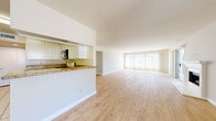Located in the desirable Silver Lake neighborhood of Los Angeles, this single-story, 3-bedroom, 2-bathroom home offers a well-designed layout with a clean, neutral aesthetic throughout. The spacious living room is a standout feature, showcasing light wood laminate flooring, a classic fireplace, and large floor-to-ceiling windows with vertical blinds that flood the space with natural light and offer views of the surrounding neighborhood. The kitchen opens directly to the living area via a pass-through counter, featuring granite countertops, white cabinetry, a stainless steel double sink, and tile flooring — a practical and connected design for everyday living. A stacked laundry unit is conveniently tucked within a hallway area near the kitchen. The generously sized primary bedroom includes mirrored sliding closet doors and large windows, contributing to a bright and airy feel. Additional bedrooms also feature light wood flooring and ample natural light. Both bathrooms are finished with tile flooring, white cabinetry, and granite countertops; the primary bath includes a skylight and a wide vanity mirror, while the second bath offers a clean, functional layout with a shower-tub combination. Four hallways provide smooth connectivity throughout the home, enhancing the overall flow of this comfortable Los Angeles residence.