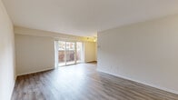 This one-bedroom, one-bathroom unit in Odenton, MD offers a well-organized layout across a single floor. The living room is bright and open, featuring light gray wood-look flooring, neutral warm-toned walls, and a ceiling fan. Sliding glass doors flood the space with natural light and open to an outdoor balcony framed by brick walls, creating a pleasant indoor-outdoor connection. The kitchen is thoughtfully updated with white shaker-style cabinetry, granite-look countertops, a stainless steel sink, and black appliances including a gas range, over-the-range microwave, dishwasher, and refrigerator. The flooring continues seamlessly from the living area into the kitchen. The bedroom offers a comfortable, cozy feel with plush carpeting, neutral walls, a window with outdoor views, and a closet. The full bathroom is clean and functional, featuring a white vanity with modern hardware, a full tub-shower combo, and matching wood-look flooring. Throughout the unit, the consistent use of light, neutral tones and updated finishes creates a cohesive and move-in-ready atmosphere suited for comfortable everyday living.