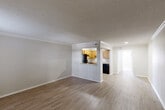 Located at 2221 Houma Blvd in Metairie, Louisiana, this single-floor, one-bedroom, one-bathroom unit offers a practical and comfortable layout. The open-concept living and dining area is finished with warm hardwood-style flooring and features crown molding and a textured ceiling, creating a clean, classic aesthetic. Natural light filters in through windows, brightening the neutral-toned walls throughout.

The kitchen is accessible directly from the living area via a pass-through counter opening, and is fully equipped with warm oak cabinetry, generous counter space, and black appliances including a refrigerator, range, and dishwasher. Light-toned flooring ties the kitchen seamlessly into the rest of the living space.

The bedroom is a comfortable, well-proportioned room featuring plush carpeting, a ceiling fan with light fixture, a window for natural light, and notably two separate closets offering ample storage. The adjoining full bathroom includes a tub/shower combination, a toilet, and a vanity with a granite-style countertop and wood cabinetry. Throughout the unit, the consistent use of neutral tones and practical finishes contributes to a functional and inviting living environment.