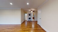 This single-floor residence combines classic detailing with practical amenities throughout its thoughtfully designed layout. Rich hardwood flooring extends across the main living areas, complemented by crisp white crown molding and neutral-toned walls that create a warm, inviting atmosphere. The spacious main living area features recessed lighting and a ceiling fan, with an elegant arched doorway adding an architectural touch that connects the space to adjoining rooms. Natural light filters in through windows fitted with blinds, offering a bright yet controllable ambiance.

The kitchen is equipped with warm wood cabinetry, striking granite countertops, a stainless steel undermount sink with a brushed nickel faucet, and a classic subway tile backsplash, combining style with functionality. A stacked washer and dryer unit is conveniently integrated within the living area, providing in-unit laundry access.

The bedroom features dual side-by-side closets, offering generous storage, along with hardwood floors and a baseboard heating system. The bathroom is finished with full tile surround, a soaking tub, a rich espresso-toned vanity, and a mirrored medicine cabinet, presenting a clean and polished aesthetic throughout.