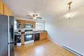 Located at 20 Scotch Grove Rd in Pulaski, NY, this two-bedroom, one-bathroom single-story home offers a practical and comfortable layout with consistent light hardwood flooring throughout. The kitchen is well-appointed with warm oak cabinetry, dark granite-style countertops, stainless steel appliances including a refrigerator, over-the-range microwave, dishwasher, and an electric range. A ceiling fan with pendant lighting and a window above the sink bring natural light and airflow into the space. The open kitchen area connects seamlessly to the rest of the home. The living room is bright and spacious, featuring a ceiling fan, baseboard heating, a wall-mounted air conditioning unit, and a sliding glass door that opens to a private patio overlooking lush greenery. Both bedrooms are finished with the same hardwood flooring, neutral tones, and baseboard heating. The primary bedroom includes a large double bi-fold closet, while the second bedroom features a window with natural light and a wall air conditioning unit. Three closets throughout the home provide ample storage. The bathroom is cleanly finished with tile flooring, a tub/shower combo, vanity, and toilet. A hallway connects all rooms for efficient flow.