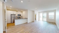 Located at 200 E 31st St in National City, CA, this well-appointed 3-bedroom, 2-bathroom residence offers a thoughtfully designed single-floor layout. The open-concept kitchen and living area serves as the heart of the home, featuring light wood-style flooring throughout, recessed lighting, and a seamless flow toward a private balcony accessed via sliding glass doors. The balcony offers expansive panoramic views of the surrounding landscape, adding an airy, elevated feel to the living space.

The kitchen is outfitted with white shaker-style cabinetry, a gray quartz peninsula countertop, stainless steel appliances including a refrigerator, range, and microwave, and a modern pull-down faucet — combining functionality with a clean, contemporary aesthetic.

The generously sized primary bedroom includes direct balcony access and ample natural light. The two additional bedrooms are bright and well-proportioned, each featuring windows with neighborhood views and the same warm wood-style flooring found throughout the unit.

Both bathrooms are finished in a crisp, clean style with white subway tile surrounds in the tub/shower combinations, modern fixtures, and wood-style flooring. Two closets provide convenient storage. A connecting hallway ties the layout together efficiently, making this a comfortable and cohesive living space.