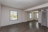 Located in the desirable Colonial Homes neighborhood of Atlanta, GA, this two-story residence offers a well-organized layout across two floors. The main level features generously sized living areas finished with light-toned hardwood-style flooring that runs throughout, complemented by neutral white walls and multiple windows fitted with blinds that allow abundant natural light. An open flow connects the living spaces, with a staircase leading to the upper level. The kitchen is thoughtfully appointed with white shaker-style cabinetry, granite countertops, a light glass subway tile backsplash, stainless steel appliances including a gas range, microwave, dishwasher, and refrigerator, as well as track lighting overhead. The bathroom features white subway tile surrounding the tub-shower combination, a white vanity with granite countertop, and a wall-mounted mirror with lighting. The upper floor houses multiple bedrooms, each finished with plush carpeting, ceiling fans with lighting, and individual closets providing ample storage. Large windows in the bedrooms frame views of the surrounding neighborhood. The overall ambiance throughout the home is bright, clean, and move-in ready, reflecting a fresh, updated interior well-suited to comfortable urban living in Atlanta.