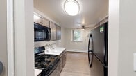 Located at 1700 W Street Rd in Warrington, PA, this well-appointed 2-bedroom, 2-bathroom residence offers a thoughtfully designed single-floor layout. The galley-style kitchen is a standout feature, boasting rich dark cabinetry with brushed nickel hardware, white quartz countertops, a mosaic tile backsplash, black appliances including a gas range and refrigerator, and light wood-style flooring that flows throughout the common areas. A ceiling fan and window in the adjacent dining area add comfort and natural brightness.

Both bedrooms are generously sized, finished with soft neutral carpet, light gray walls, and large windows that invite natural light and views of the surrounding greenery. Each room also includes wall-mounted air conditioning units and baseboard heating, ensuring year-round comfort. The primary bedroom features a closet for added storage.

The two bathrooms are cleanly updated. The full bath offers a tub-shower combination with classic white subway tile accented by a decorative mosaic border, paired with wood-look flooring. The second bathroom is a compact, bright half-style bath with a white vanity, mirror, and matching wood-look flooring. A connecting hallway ties the layout together efficiently, creating a cohesive and functional living space.