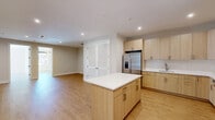 Located at 684 Main Ave in Passaic, NJ, this well-appointed 2-bedroom, 1-bathroom unit offers a thoughtfully designed layout with modern finishes throughout. Light wood flooring flows seamlessly across the entire space, creating a warm and cohesive aesthetic in every room. The open-concept kitchen and living area serves as the heart of the unit, anchored by a sleek kitchen featuring light wood cabinetry, white subway tile backsplash, stainless steel appliances, and a central island with a crisp white countertop — ideal for both cooking and casual dining. Recessed lighting illuminates the space effectively. The primary bedroom is generously sized, bathed in natural light from a large window framed by navy roller shades, and topped with a striking sputnik chandelier that adds a modern touch. The second bedroom also features louvered closet doors and recessed lighting, offering functional storage and a clean design. The full bathroom is finished with large-format marble-style floor and wall tiles, a floating wood vanity with an integrated white basin, an illuminated LED mirror, and a tub-shower combination with a sleek black-framed glass door. The unit's neutral palette and modern fixtures create a bright, move-in-ready living environment.
