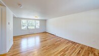 Located at 71 Redden Ave in New London, Connecticut, this two-story home offers three bedrooms and two bathrooms thoughtfully distributed across two floors. The main level features a combined kitchen and living area, where warm hardwood floors flow through bright, open rooms filled with natural light from large windows dressed with horizontal blinds. The living room is generously sized, with views of the surrounding greenery that lend a peaceful, residential ambiance throughout.

The kitchen is well-equipped with warm-toned oak cabinetry, ample counter space, and white appliances including a gas range, refrigerator, and dishwasher. Light tile flooring and a ceiling-mounted light fixture complete the functional layout. A hallway connects the main living spaces and provides access to a full bathroom on this level, featuring tile flooring, a wood vanity, and a window for natural light.

The upper floor houses the bedrooms, including a spacious primary bedroom, all finished with classic hardwood floors and crisp white walls. The second full bathroom mirrors the clean, simple aesthetic found throughout, with tile flooring, a wood vanity with a white countertop, and dual windows overlooking lush outdoor scenery. Baseboard heating is present throughout both floors, ensuring year-round comfort in this well-maintained New London residence.