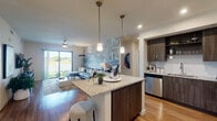 This single-floor residence in Boca Raton, Florida, offers a thoughtfully designed open-concept layout with contemporary finishes throughout. The kitchen serves as a central hub, outfitted with dark wood cabinetry extending to the ceiling, stainless steel appliances, and a granite-topped island with bar seating illuminated by pendant lighting. Wood-look flooring flows seamlessly from the kitchen into the living area, which features a striking geometric accent wall and sliding glass doors that invite natural light and provide outdoor views. A ceiling fan adds to the Florida-friendly comfort of the space. An in-unit laundry area is conveniently tucked near the kitchen corridor.

The bedrooms are calm and comfortable, each featuring wood-look flooring, natural light from well-placed windows, and neutral tones that create a restful atmosphere. The bathrooms are finished to a high standard: one features a double vanity with granite countertops, backlit mirrors, and a glass-enclosed walk-in shower, while another includes a granite vanity and a full bathtub with shower combination. Together, these spaces reflect a cohesive modern aesthetic well-suited to the South Florida lifestyle.