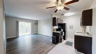 Located at 2500 Beechmont Ave in Cincinnati, Ohio, this single-floor, 2-bedroom, 1-bathroom residence offers a practical and comfortable layout. The open living area is finished with durable hardwood-style flooring and neutral gray walls, creating a clean, modern atmosphere. A ceiling fan adds functionality, while a baseboard heating system runs throughout the main living spaces. Sliding glass doors lead to a private balcony that overlooks lush greenery, bringing in generous natural light and pleasant outdoor views.

The kitchen features dark cabinetry, granite-look countertops, tile flooring, and black appliances including a refrigerator and dishwasher. A hallway connects the main living area to the bedrooms and bathroom, providing a logical flow throughout the home.

Both bedrooms are carpeted for comfort and feature neutral tones, baseboard heating, and wall-mounted AC units. The spacious primary bedroom offers ample room and direct access to the hallway. The second bedroom includes a built-in closet with sliding doors. The full bathroom is outfitted with a clean white tub-shower surround and chrome fixtures.

A dedicated closet provides additional storage, rounding out this efficiently designed and move-in ready residence.