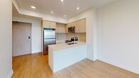This well-appointed one-bedroom, one-bathroom unit at 150 Wissler Road in Waterloo, Ontario offers a thoughtfully designed layout across a single floor. Light hardwood flooring flows throughout the living areas and bedroom, creating a warm, cohesive aesthetic complemented by crisp white walls and recessed lighting.

The open-concept kitchen is a functional highlight, featuring light wood cabinetry extending to the ceiling for ample storage, a full suite of stainless steel appliances including a refrigerator, electric range, built-in microwave, and dishwasher, and a peninsula with a double undermount sink — ideal for both cooking and casual dining.

The bedroom is a comfortable, well-proportioned retreat with a large window fitted with a roller blind that frames pleasant views of the surrounding Waterloo neighbourhood and its mature tree canopy. A built-in sliding-door closet provides practical storage.

The bathroom is finished in a clean, neutral palette with large-format floor tiles, white subway tile surrounding the full bathtub and shower, a wood-toned vanity, and recessed lighting. A utility room rounds out the unit's functional spaces. The overall ambiance is modern, bright, and move-in ready.
