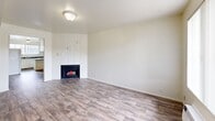 Located at 4545 S Atherton Dr in Taylorsville, Utah, this single-floor residence offers a practical and comfortable layout with two bedrooms and two bathrooms. The living room serves as the heart of the home, featuring wood-look plank flooring, a white-tiled fireplace as a standout focal point, and a window that brings in natural light. A wall-unit air conditioner and a front entry door are also found in this main living area. The kitchen is efficiently designed with white cabinetry, dark countertops, a double sink, and white appliances including a refrigerator, electric range, and dishwasher. Wood-look flooring continues throughout the kitchen, which also benefits from a window providing additional natural light. Both bedrooms are finished with plush carpet and are served by individual windows dressed with vertical blinds. The spacious primary bedroom features dual closets with bifold doors, offering generous storage. The second bedroom is comfortably sized with its own closet access. The two bathrooms are cleanly finished, with one featuring wood-look tile flooring, a vanity with dark countertop, and a full tub-shower combo with white tile surround. A hallway connects the main areas, completing this well-organized and functional floor plan.