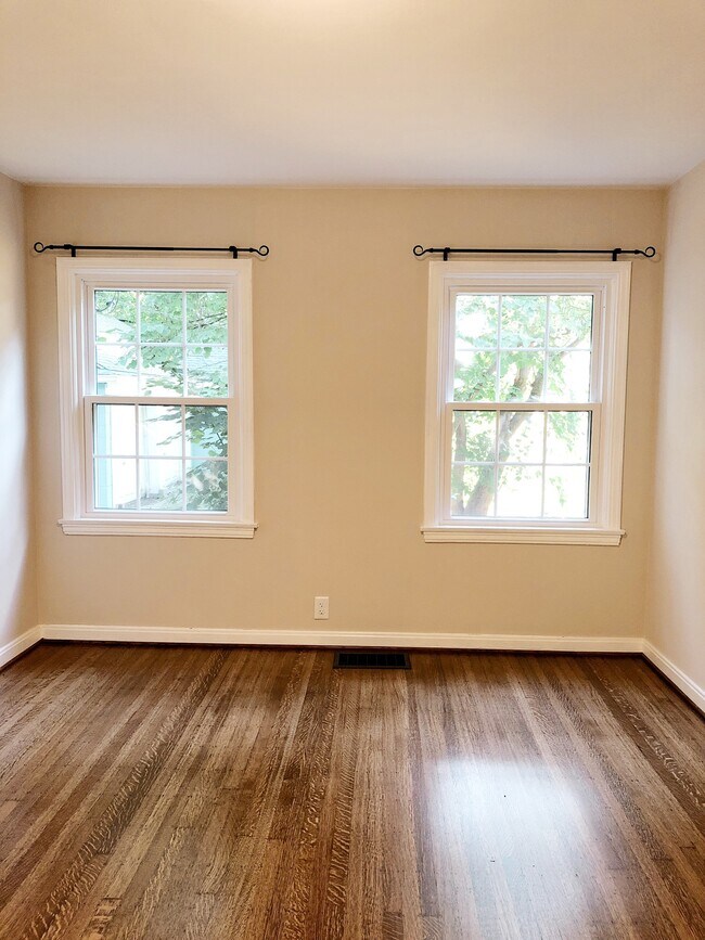 Natural sunlight streams through the bedroom windows to highlight the natural beauty of the refinished hardwood floors - 5882 Primrose Avenue