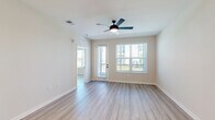 Located at 4741 Hoffner Ave in Orlando, FL, this well-appointed single-floor residence offers three bedrooms, three bathrooms, and three closets within a thoughtfully designed layout. Light-toned wood-style flooring runs throughout, lending a clean, cohesive aesthetic to every room.

The open-concept kitchen and living area serves as the heart of the home. The kitchen features warm wood cabinetry with open shelving, white quartz countertops, stainless steel appliances, recessed lighting, and a central island that provides additional workspace and casual seating. The living area flows naturally from the kitchen and is filled with natural light from large windows fitted with blinds.

Each bedroom is finished with the same light wood flooring and includes a ceiling fan. The primary bedroom is a generously sized retreat with access to a private outdoor area through a glass door, offering views of the outdoors. Additional bedrooms feature large windows and ceiling fans, creating bright, comfortable spaces. Each bedroom benefits from dedicated closet space, including a walk-in closet with wire shelving for ample storage.

The bathrooms are finished with elegant marble-style tile surrounds in the tub and shower areas. The neutral, light color palette used throughout the home creates a calm, airy ambiance that complements the modern design.