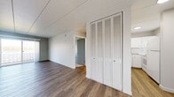 Located at 4235 Americana Dr in Cuyahoga Falls, Ohio, this two-bedroom, one-bathroom unit offers a practical and clean single-floor layout. The living area is open and elongated, featuring durable wood-style laminate flooring, white panel walls, and a sliding glass door that welcomes natural light and provides outdoor access. The kitchen is efficiently designed in an L-shaped configuration, outfitted with white cabinetry, white countertops, a stainless steel double-basin sink with a modern faucet, and white appliances including a range and refrigerator, all set on wood-style flooring with a tile backsplash.

Both bedrooms are carpeted for comfort and feature neutral gray walls. The primary bedroom includes a large louvered bi-fold closet and connects to the main living area, while the second bedroom offers a window with blinds that brings in natural light. A hallway closet with matching louvered doors adds additional storage to the unit. The full bathroom is bright and clean, featuring a tiled tub-and-shower combo, a white vanity with a mirror, and wood-style flooring. Throughout the unit, the consistent use of white tones and neutral finishes creates a cohesive, understated aesthetic.