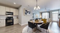 Located at 11240 Woolwich St in Charlotte, NC, this single-floor, 2-bedroom, 2-bathroom residence offers a thoughtfully designed open-concept layout that seamlessly connects the kitchen, dining, and living areas. Wood-style flooring flows throughout the main living spaces, anchored by a dedicated entrance and a cohesive neutral color palette.

The kitchen features light wood cabinetry, granite countertops, a white subway tile backsplash, and black Whirlpool appliances, including a range and over-the-range microwave. The adjoining dining area is illuminated by a modern pendant chandelier, while the living room benefits from large windows that invite abundant natural light and a ceiling fan overhead.

Both bedrooms are carpeted and generously proportioned, with the primary bedroom offering ample space for a full suite of furniture. Each bedroom is served by a closet for organized storage. The bathrooms include wood-style flooring, white vanity cabinetry with white countertops, and a tiled tub-shower combination. A dedicated laundry room houses a full-size Whirlpool washer and dryer. The layout also includes two closets for additional storage, rounding out a functional and comfortable living space.