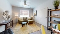 Located at 1009 NE Sixth St in Oklahoma City, Oklahoma, this single-story unit offers a thoughtfully designed layout with modern finishes and a clean, contemporary aesthetic. The living area serves as the heart of the space, featuring light hardwood-style flooring, neutral gray walls, and a ceiling fan overhead. A large window allows natural light to fill the room, creating a bright and welcoming atmosphere. An open shelving unit near the entry adds both functionality and visual interest.

The kitchen is well-equipped with white cabinetry extending to the ceiling, gray laminate countertops, and stainless steel appliances, including an electric range with an over-the-range microwave. The layout maximizes storage and counter space efficiently. Adjacent to the kitchen, a nook with hardwood-style flooring provides additional flex space.

The unit includes two bedrooms, each carpeted for comfort and fitted with ceiling fans. Both rooms offer adequate space for full bedroom furnishings, and one features dual windows that bring in natural light. The bathroom presents white cabinetry with brushed nickel hardware, a dark countertop, a framed mirror, and a well-lit vanity fixture. Built-in shelving nearby adds convenient storage. The overall design is consistent and modern throughout.