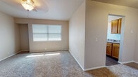 Located at 1200 E Ayers St in Edmond, Oklahoma, this single-floor home offers a straightforward and functional layout suited for comfortable everyday living. The living area is finished with neutral-toned carpet and features a ceiling fan with a light fixture, along with a large window fitted with horizontal blinds that allows natural light to fill the space. The open layout connects well to adjoining areas of the home.

The kitchen is equipped with warm-toned wooden cabinetry, laminate countertops, a double-basin stainless steel sink, and dark hardwood-style flooring. A window above the sink brings in additional natural light, and the kitchen accommodates standard appliances including a range and dishwasher.

The bedrooms are carpeted with neutral walls and offer a quiet, clean atmosphere. Each room includes windows with blinds, ceiling fixtures, and closet access. The layout, as visible from the floor plan overview, includes multiple rooms arranged along a central corridor with easy access throughout.

The bathroom features a dark wood vanity with a light stone-top single sink, a combination tub and shower unit, and a multi-globe overhead light fixture. Dark hardwood-style flooring ties the bathroom together cohesively. Overall, this home presents a clean, practical interior with consistent finishes throughout.