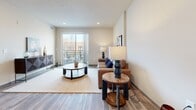 Located at 215 3rd St in Wausau, WI, this thoughtfully designed one-bedroom, one-bathroom unit offers a comfortable and efficient layout across a single floor. The open-concept kitchen and living area serves as the heart of the space, featuring rich dark-toned cabinetry, stainless steel appliances including a refrigerator, range, microwave, and dishwasher, and a light quartz countertop island with bar seating — ideal for both cooking and casual dining. Wood-look plank flooring runs throughout the main living areas, adding warmth and continuity. The living room is bright and inviting, with recessed lighting and a sliding glass door that opens to a private balcony with views of the surrounding streetscape. The bedroom offers a cozy, carpeted retreat with multiple windows that bring in natural light and include a closet for ample storage. The bathroom is finished with dark wood cabinetry, a single vanity with stone countertop, wood-look tile flooring, and a walk-in shower. A dedicated laundry area houses a stacked full-size washer and dryer unit alongside additional shelving. The hallway connects all rooms efficiently, completing a well-organized and modern floor plan suited for everyday living.
