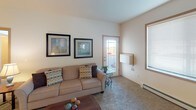 This single-floor residence in Fargo, North Dakota offers a well-organized layout designed for comfortable everyday living. The kitchen is equipped with ample honey-toned cabinetry, granite-style countertops, and black appliances including a refrigerator, range, microwave, and dishwasher. A dining area adjacent to the kitchen provides space for a full table and chairs, with wood-look flooring tying the two areas together seamlessly.

The living room features plush carpeting, large windows that allow natural light to fill the room, and a sliding glass door that opens to a private balcony with outdoor views. Baseboard heating runs throughout the carpeted areas of the home, ensuring warmth during colder months.

Multiple bedrooms offer restful retreats, each with generous windows, soft carpeting, and ample wall space. The bedrooms benefit from natural light and views of the surrounding neighborhood. The bathrooms are clean and functional, each featuring a full tub-shower combination, with one bathroom showcasing warm wood cabinetry and tile flooring, while the second is finished in a bright, crisp style. The overall ambiance of the space is warm, neutral, and practical, making it a comfortable and inviting place to call home.