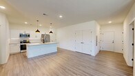 Located at 200 Aycock Avenue in Monroe, GA, this single-story, 2-bedroom, 2-bathroom home offers a thoughtfully designed open-concept layout with modern finishes throughout. Light-toned luxury vinyl plank flooring flows seamlessly across the entire home, creating a cohesive and clean aesthetic.

The kitchen is a standout feature, boasting white shaker cabinetry with matte black hardware, granite countertops, stainless steel appliances, and a large island with an undermount sink and stylish pendant lighting above. The kitchen opens directly to the living area, which benefits from abundant natural light through large windows, a ceiling fan, and direct access to the exterior via a glass-panel door.

The primary bedroom is generously sized and includes a spacious walk-in closet with wire shelving systems offering ample storage. Both bathrooms are finished with white cabinetry, granite countertops, undermount sinks, and brushed nickel fixtures. A second closet provides additional storage convenience.

Throughout the home, crisp white walls, recessed lighting, and clean architectural lines contribute to a bright, modern, and move-in-ready atmosphere. The single-floor layout ensures easy accessibility and functional flow between all rooms.