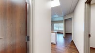 Located on Fifth Ave S in La Crosse, Wisconsin, this one-bedroom, one-bathroom unit offers a practical and well-organized layout across a single floor. Rich wood-look flooring runs consistently throughout the space, complemented by neutral wall tones and warm wood-trimmed baseboards that give the unit a cohesive, clean aesthetic.

The combined kitchen and living area serves as the heart of the unit. The kitchen features a central island with a built-in sink and stone-look laminate countertops, white cabinetry, white appliances including a range, microwave, and refrigerator, and a drop ceiling with recessed light panels. A large window allows natural light to fill the space.

The bedroom is a comfortable, well-lit room with a broad window fitted with blinds and a baseboard heater, providing a quiet and bright retreat. An additional den offers flexible space suitable for a home office or secondary sitting area, also finished with the same wood-look flooring and a baseboard heater.

The bathroom includes a full tub-shower combination with a handheld showerhead, a white vanity with stone-look countertop, and continued wood-look flooring. An adjacent built-in shelved closet provides convenient storage. Two closets throughout the unit offer ample organizational space, completing this functional and neatly appointed home.