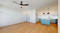 Located at 5300 Las Soleras Dr in Santa Fe, New Mexico, this thoughtfully designed one-bedroom, one-bathroom residence offers a clean, modern aesthetic throughout. Light wood-look flooring runs through the main living areas, complemented by crisp white walls and black hardware accents that create a cohesive, contemporary feel.

The open-concept kitchen and living room form the heart of the unit. The kitchen is well-appointed with shaker-style cabinetry in white and soft sage-green tones, quartz countertops, a subway tile backsplash, stainless steel appliances, and a peninsula with pendant lighting — ideal for both cooking and casual dining. The living area is bright and airy, benefiting from multiple windows that bring in natural light, a ceiling fan, and direct access to a private patio.

The bedroom offers a comfortable retreat with plush carpeting, two windows, and a ceiling fan. A dedicated walk-in closet with wire shelving provides convenient storage. The full bathroom features wood-look flooring, a white quartz vanity with sage cabinetry and matte black fixtures, an illuminated LED mirror, and a walk-in shower with a sleek glass enclosure. A secondary closet is also accessible from the bathroom. The entry foyer provides a welcoming transition into the home with recessed lighting overhead.