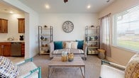 This two-story home offers a thoughtfully designed layout with a variety of functional and comfortable living spaces. At its heart is a generously sized kitchen showcasing warm, natural wood cabinetry, crisp white countertops, a large central island with a matching wood base, light wood-look tile flooring, and a full suite of stainless steel appliances — including a range, microwave, refrigerator, and dishwasher. Recessed lighting illuminates the space, creating a bright and welcoming atmosphere ideal for cooking and gathering.

The upper level features multiple bedrooms carpeted in neutral tones, including a versatile nursery or secondary bedroom with neighborhood views through well-sized windows. A cozy sitting or bonus room on the upper floor is bathed in natural light from dual windows and offers a relaxed, comfortable retreat. Bathrooms throughout the home are finished in clean, light tones with tile flooring, tub-shower combinations, and modern vanities.

A dedicated laundry room houses a full-size washer and dryer alongside built-in shelving for added storage. The overall aesthetic of the home is clean and contemporary, with neutral walls, consistent finishes, and an open, airy feel that flows seamlessly between levels.