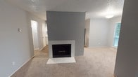 Located at 2101 Park Springs Blvd in Arlington, Texas, this single-story residence offers a well-organized layout with a clean, neutral aesthetic defined by soft gray walls and updated finishes throughout. The living area serves as the centerpiece of the home, anchored by a striking fireplace framed in white tile with a bold gray accent wall rising to the textured ceiling — a standout architectural detail that adds depth and character to the space. Plush carpeting extends across the living and bedroom areas, creating a warm, comfortable feel. The galley-style kitchen is thoughtfully appointed with white cabinetry, light quartz-style countertops, a gray subway tile backsplash, wood-look vinyl flooring, track lighting, and stainless steel appliances including a range and built-in microwave. The bedrooms offer carpeted floors, natural light through blinded windows, and ceiling fans for comfort. The primary bedroom includes dual walk-in closets and direct access to a full bathroom featuring a tub-shower combination with white tile surround, wood-look flooring, and a granite-style vanity. A second full bathroom mirrors the updated finishes found throughout the home. This residence presents a cohesive, move-in-ready interior with modern updates at every turn.
