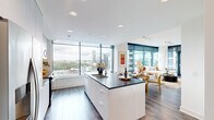 Located in the heart of Midtown Atlanta on West Peachtree Street, this well-appointed 2-bedroom, 3-bathroom residence delivers a refined urban living experience. The open-concept layout is anchored by a sleek, modern kitchen featuring a large center island with dark stone countertops, white cabinetry, stainless steel appliances, and glass shelving with mirrored accents. Floor-to-ceiling windows flood the space with natural light and frame dramatic views of the Atlanta skyline and surrounding cityscape.

The living room extends the open design with access to a private balcony through full-height glass doors, offering additional skyline views. Rich hardwood-style flooring runs throughout, adding warmth to the contemporary aesthetic. Both bedrooms are generously sized, each with large windows showcasing sweeping city views and ceiling fans for comfort. The spacious primary suite includes a walk-in closet with built-in shelving systems and an en-suite bathroom with marble-style tile and a glass-enclosed shower.

A dedicated laundry room houses a full-size washer and dryer beneath overhead cabinetry and a dark stone folding counter. A wide hallway connects all rooms, maintaining a clean, organized flow throughout. Three full bathrooms and two closets round out this thoughtfully designed urban residence.