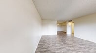 Located at 4255 W Viking Rd in Las Vegas, NV, this one-bedroom, one-bathroom unit offers a well-organized single-floor layout designed for comfortable everyday living. The open-concept living room features wood-look laminate flooring, a textured ceiling, and a window that brings in natural light and views of the surrounding neighborhood. It flows seamlessly into a dedicated dining or flex area, also finished with the same laminate flooring and illuminated by a pendant light fixture. The galley-style kitchen is outfitted with warm wood cabinetry, light stone-finish countertops, a full suite of white appliances including a range, refrigerator, and dishwasher, and a built-in sink — all laid out efficiently along two parallel walls. The bedroom is a comfortable, carpeted retreat with a window offering outdoor views and access to a spacious walk-in closet featuring wrap-around hanging rods and built-in shelving for generous storage. The bathroom includes a combination tub and shower, a vanity with stone-finish countertop, wood cabinetry, and wood-look flooring. A hallway connects the rooms, completing this practical and well-appointed Las Vegas residence.