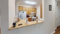 This single-floor, 2-bedroom, 2-bathroom residence offers a practical and comfortable layout designed for everyday living. The open-concept floor plan connects the main living areas seamlessly, with warm hardwood flooring running throughout the common spaces, adding a consistent and inviting character to the home.

The kitchen is equipped with ample cabinetry in a honey oak finish, a full suite of appliances including a side-by-side refrigerator with ice and water dispenser, and a white range. A pass-through breakfast bar connects the kitchen to the adjacent living area, making it ideal for casual dining and conversation.

The living room is a welcoming space featuring hardwood floors, a large window that brings in natural light, and neutral-toned walls that create a bright and airy atmosphere.

Both bedrooms are carpeted and feature neutral wall tones, windows with natural light, and ample room for furnishings. The primary bedroom includes its own private bathroom conveniently accessible from within the room. The second bedroom is equally comfortable, with a window providing natural light and a relaxed, cozy feel.

Two full bathrooms serve the home, each featuring tile flooring, a vanity with wood cabinetry, and standard fixtures. The overall layout is efficient and well-organized, making this a functional and comfortable living space.