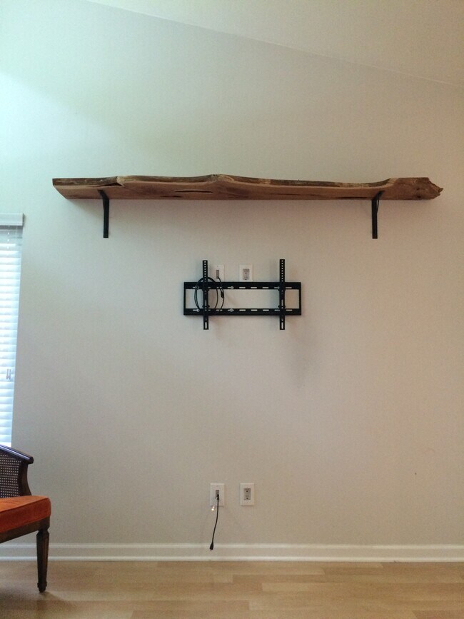 TV mount, hidden wires, and live edge natural cedar shelf across from the couch in the living room. - 706 Tyler Road