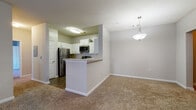 Located at 2100 Shiloh Valley Dr NW in Kennesaw, GA, this Type C1 single-floor unit offers a well-designed layout with a seamless flow between living, dining, and kitchen areas. The kitchen is a functional highlight, featuring white shaker-style cabinetry, granite countertops, a decorative tile backsplash, wood-style vinyl plank flooring, and a full suite of stainless steel appliances including a refrigerator, range, microwave, and dishwasher. A peninsula with a granite overhang connects the kitchen to the dining and living areas, which are accented by a stylish pendant light fixture. The living area is generously sized with plush carpeting, a ceiling fan, and access to an outdoor area through a glass door. Bedrooms are carpeted and filled with natural light from multiple windows with blinds. Each bedroom includes walk-in or reach-in closet space with built-in wire shelving. The bathrooms are outfitted with white vanities, granite countertops, and tub-shower combinations with white tile surrounds and wood-style flooring. Neutral gray walls and consistent finishes throughout give the unit a clean, cohesive aesthetic.