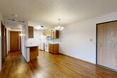 Located at 6500 W 43rd St in Sioux Falls, South Dakota, this 2-bedroom, 1-bathroom unit offers a functional and well-organized single-floor layout. The open-concept living and dining area features rich hardwood-style flooring and transitions seamlessly into carpeted zones, creating a comfortable and cohesive feel. A pendant chandelier adds a welcoming touch above the dining space, while a sliding glass door leads to a private balcony, bringing in natural light and outdoor access.

The kitchen is equipped with warm oak cabinetry, white appliances including a range, microwave, refrigerator, and dishwasher, and offers ample counter space with a convenient peninsula that opens to the living area. A textured ceiling runs throughout the main living spaces, adding a classic character to the interior.

Both bedrooms are carpeted and offer generous closet space with sliding wood-panel closet doors. The primary bedroom is a comfortable size, complemented by a baseboard heating unit. The second bedroom features a window that allows natural light to brighten the space.

The full bathroom includes an oak vanity with a white countertop, a tub-shower combination, and wood-look tile flooring. Clean and straightforward in design, this unit provides practical living in a convenient Sioux Falls location.