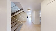 Located at 1000 Dumont Blvd in Las Vegas, Nevada, this two-story residence offers 2 bedrooms and 3 bathrooms across two well-proportioned floors. The main level features a bright, open living room with large-format tile flooring, a striking fireplace with a mirrored surround, a sliding glass door leading to an outdoor area, and a distinctive whitewashed brick accent wall that runs throughout the home, lending a consistent architectural character. The kitchen connects to the living area via a pass-through counter and features granite-look countertops, white cabinetry, a gas range, a dishwasher, and tile flooring. A dedicated laundry room with a full-size washer and dryer adds everyday convenience. The bathrooms are clean and functional, featuring extended vanity countertops and the same signature brick wall detailing. Upstairs, the bedrooms are carpeted and generously sized. The spacious primary bedroom includes an expansive built-in closet system with open shelving, hanging rods, and integrated drawers, offering ample storage. The secondary bedroom also features a brick accent wall, a window with natural light, and closet access. A staircase connects both levels, completing this well-laid-out multi-floor home.