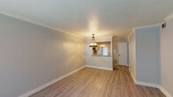 Located at 2501 Westridge St in Houston, TX, this thoughtfully updated single-story unit showcases a cohesive blend of modern finishes and functional design throughout. Light-toned luxury vinyl plank flooring flows seamlessly across the living, dining, and bedroom areas, creating a clean, uniform aesthetic. The open living and dining area is highlighted by crown molding, neutral gray walls, and a decorative chandelier that anchors the space. A pass-through opening connects the dining area to the kitchen, enhancing the sense of openness. The kitchen is well-appointed with gray cabinetry, striking granite countertops, a tile backsplash, a deep undermount sink with a matte black faucet, and pendant lighting — all paired with black appliances for a cohesive look. Natural light filters into the bedrooms through window blinds, with each room offering generous proportions, light-toned flooring, and ample closet space. The bathrooms are a standout feature, each boasting granite vanity tops, distinctive green glass vessel sinks, matte black faucets, and wood-framed mirrors. The full bathroom includes a tiled tub surround with a decorative accent border. Clean lines and updated finishes throughout make this a well-presented Houston residence.