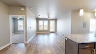 This well-appointed 2-bedroom, 2-bathroom residence in Odessa, TX offers a thoughtfully designed single-floor layout with modern finishes throughout. The open-concept kitchen and living area serves as the heart of the home, anchored by a large center island with a granite countertop and undermount sink, illuminated by elegant pendant lighting. Dark espresso cabinetry, a subway tile backsplash, and a full suite of stainless steel appliances — including a French door refrigerator, electric range, and built-in microwave — complete the kitchen. Wood-look luxury vinyl flooring extends through the main living areas, adding warmth and durability. The living area features neutral toned walls, ample natural light from large windows, and access to an exterior door. Both bedrooms are carpeted and offer generous natural light through double windows with blinds. The spacious primary bedroom connects to a well-equipped bathroom featuring a granite-topped vanity with dark cabinetry, a large mirror, and a tiled soaking tub/shower combination. A walk-in closet with wire shelving provides convenient storage. The second bathroom mirrors the same quality finishes, maintaining a cohesive and polished aesthetic throughout the home.