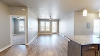 This well-appointed 2-bedroom, 2-bathroom residence in Odessa, TX offers a thoughtfully designed single-floor layout with modern finishes throughout. The open-concept kitchen and living area serves as the heart of the home, anchored by a large center island with a granite countertop and undermount sink, illuminated by elegant pendant lighting. Dark espresso cabinetry, a subway tile backsplash, and a full suite of stainless steel appliances — including a French door refrigerator, electric range, and built-in microwave — complete the kitchen. Wood-look luxury vinyl flooring extends through the main living areas, adding warmth and durability. The living area features neutral toned walls, ample natural light from large windows, and access to an exterior door. Both bedrooms are carpeted and offer generous natural light through double windows with blinds. The spacious primary bedroom connects to a well-equipped bathroom featuring a granite-topped vanity with dark cabinetry, a large mirror, and a tiled soaking tub/shower combination. A walk-in closet with wire shelving provides convenient storage. The second bathroom mirrors the same quality finishes, maintaining a cohesive and polished aesthetic throughout the home.