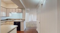 Located at 3961 Abby Ln in Johnson, Arkansas, this single-floor home offers a well-organized layout with a thoughtful blend of hard flooring and plush carpeting throughout. The kitchen is a functional centerpiece, featuring light wood cabinetry extending to the ceiling for ample storage, black appliances including an electric range, over-the-range microwave, dishwasher, and refrigerator, along with a double basin sink and a peninsula that provides additional counter space and a natural transition into the main living areas. Hard wood-style flooring runs through the kitchen and entry, while soft, neutral carpet flows into the living room and bedrooms. The spacious living room is bright and airy, benefiting from large windows fitted with blinds and a ceiling fan overhead. Multiple bedrooms continue the carpeted aesthetic, each with ceiling fans and generously sized windows — one bedroom features a charming bay window configuration that draws in abundant natural light. The bathrooms are clean and practical, with one offering a vanity with an integrated sink, overhead cabinetry for storage, and a toilet, while another includes a standalone shower stall and similar storage solutions. Textured ceilings are present throughout, and the home's neutral color palette creates a cohesive, move-in ready atmosphere.