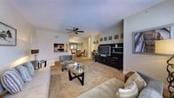This well-appointed 1-bedroom, 1-bathroom residence offers a thoughtfully designed single-floor layout that maximizes both comfort and functionality. The open-concept living area serves as the heart of the home, featuring plush wall-to-wall carpeting, neutral tones, and a ceiling fan that enhances the bright, airy atmosphere. A sleek entertainment center with built-in shelving provides a stylish focal point, while a glass-top coffee table and comfortable seating complete the inviting living space. The living area flows naturally into the dining space, which is illuminated by a modern overhead light fixture and comfortably accommodates a full dining set. A pass-through window connects the dining area to the kitchen, which offers a glimpse of updated cabinetry and contemporary fixtures, creating a sense of openness throughout. The neutral color palette and consistent flooring choices tie each area together cohesively. The layout is efficient yet spacious, making excellent use of the available square footage to provide a comfortable living environment suitable for a variety of lifestyles.
