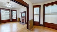 Located at 2010 Park Ave in Minneapolis, this single-floor unit blends classic architectural character with functional design. The space includes a living room, kitchen, and bathroom, offering an efficient and well-organized layout.

The living room is the standout space, showcasing rich, dark-stained wood trim framing the doorways, windows, and a decorative brick fireplace with an ornate wooden mantel. Warm hardwood floors run throughout, complementing the historic millwork. Multiple windows allow natural light to fill the room, while a ceiling fan adds practicality. Cast-iron radiators reinforce the building's period character.

The kitchen features warm oak cabinetry with ample upper and lower storage, dark countertops, a gas range, and a single-basin sink. A globe pendant light illuminates the space, and the hardwood flooring continues from the main living area. A paneled wood entry door with a transom window adds to the vintage aesthetic.

The bathroom is clean and straightforward, featuring white tile surrounding a full tub-shower combination, a pedestal sink, and a medicine cabinet mirror.

Throughout the unit, dark wood baseboards, paneled doors, and consistent hardwood flooring tie the rooms together, creating a cohesive space with notable historic charm.