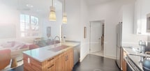 This 630 square foot apartment in Philadelphia offers a harmonious blend of modern design and practical living. The space is efficiently laid out on a single floor, comprising a bedroom, living room, kitchen, and closet. The kitchen is a standout feature, boasting sleek stainless steel appliances, including a full-size refrigerator and range, complemented by a mix of white and wood-tone cabinetry. The living area is bathed in natural light from large, arched windows, creating an airy ambiance. It's furnished with a comfortable sectional sofa and stylish accent pieces. The bedroom, measuring 140 square feet, features a modern four-poster bed and large windows offering outdoor views. High ceilings throughout add to the sense of spaciousness, while the cohesive white color scheme enhances the apartment's bright, contemporary feel. Thoughtful storage solutions and minimalist decor contribute to the overall clean, uncluttered aesthetic of this urban dwelling.