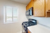Located at 2500 Queens Chapel Rd in Hyattsville, MD, this two-bedroom, one-bathroom residence offers a straightforward and functional single-floor layout. The interior is finished in a clean, neutral palette throughout, creating a bright and cohesive atmosphere.

The kitchen features light wood cabinetry, a gas range with an over-the-range microwave, and light-toned countertops. A window above the counter area allows natural light to fill the space, and durable hard-surface flooring completes the room.

Both bedrooms are carpeted in a warm neutral tone and feature windows with horizontal blinds that frame views of surrounding greenery. The primary bedroom is generously sized and includes two closets, providing ample storage. The second bedroom also benefits from natural light and its own closet space.

The bathroom is finished with white tile wainscoting, light tile flooring, a white vanity with a medicine cabinet mirror, and a well-lit vanity bar — giving the room a clean and bright character.

A hallway connects the main living areas, and an additional closet offers further storage. The open living area is carpeted and offers a spacious, versatile footprint well-suited for a variety of furniture arrangements. Overall, the residence presents a clean, move-in ready environment with consistent finishes throughout.